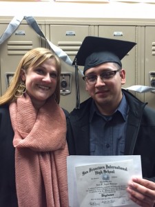 Juan Fernando shows off his graduation diploma with Julie Kessler, Principal. 